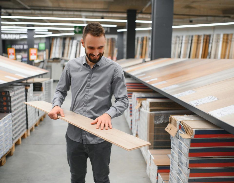 Parchet dublu stratificat, preț văzut de un bărbat, într-un magazin de bricolaj